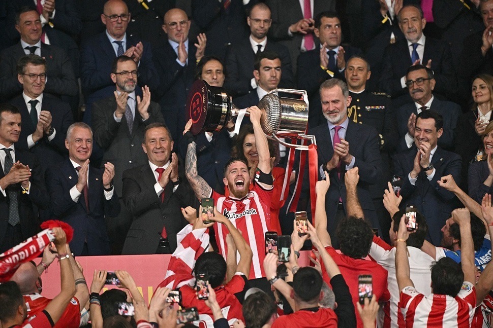 Athletic Bilbao's Spanish forward #10 Iker Muniain holds the Copa del Rey trophy next to Spain's King Felipe VI (C,R) at the end of the Spanish Copa del Rey (King's Cup) final football match between Athletic Club Bilbao and RCD Mallorca at La Cartuja stadium in Seville on April 6, 2024. (Photo by JAVIER SORIANO / AFP) (Photo by JAVIER SORIANO/AFP via Getty Images)